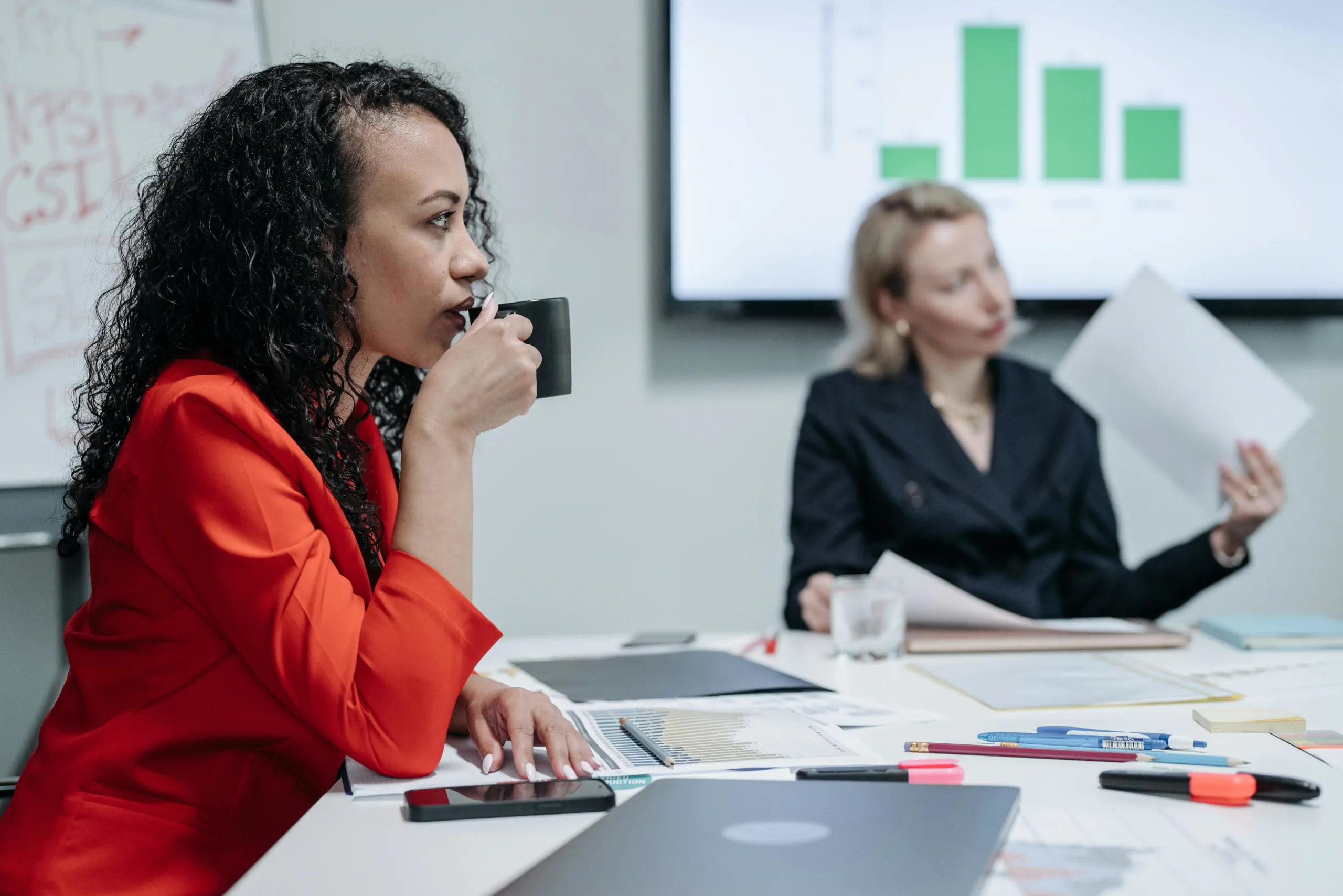 een vrouw in een vergadering drinkt van een kop koffie